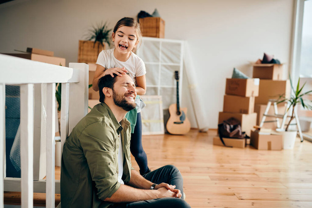 Playful father and daughter having fun while relocating in a new apartment.  - 写真・画像