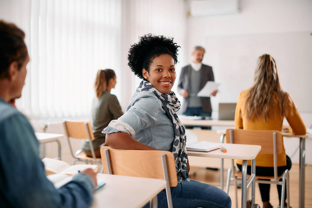 Happy African American woman attending lecture in the classroom and looking at camera. - 写真・画像