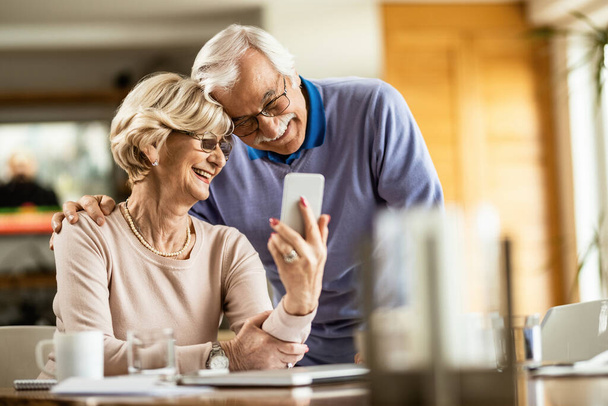 Happy mature couple having fun while using smart phone and taking selfie at home.  - Fotoğraf, Görsel