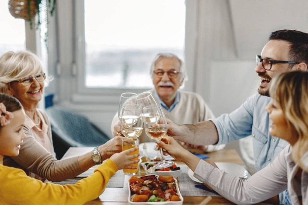 Щаслива багатоповерхова родина розважається під час тостів під час їжі в їдальні
.  - Фото, зображення