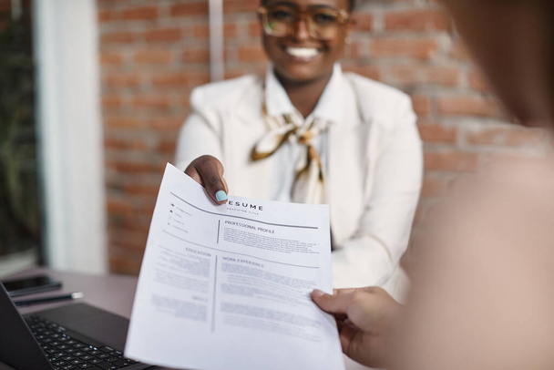 Close-up of African American candidate giving her CV to human resource manager on a job interview in the office.  - Foto, Bild