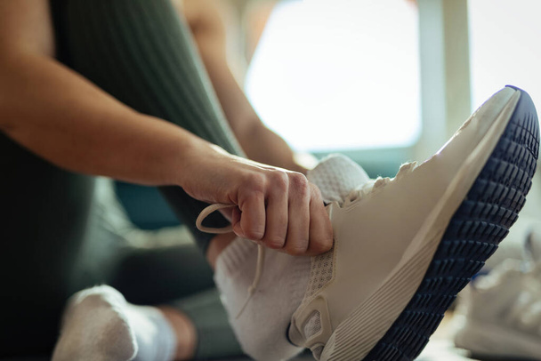 Close-up of athletic woman preparing for the workout and putting on her sport shoes.  - Photo, image