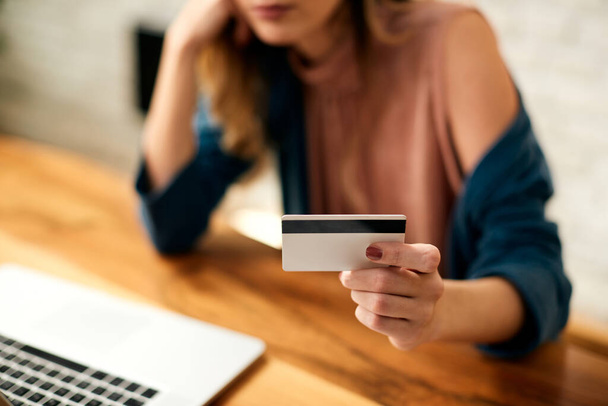 Close-up of woman using credit card and laptop for online shopping at home. - Foto, afbeelding