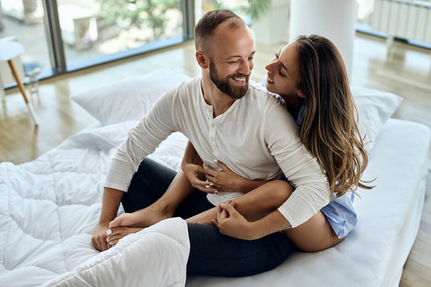 Young couple communicating and having fun while relaxing in the bedroom.  - Fotoğraf, Görsel