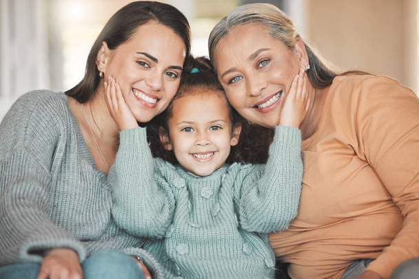 Portrait of a mature woman boding with her daughter and granddaughter on the sofa at home. - Foto, imagen
