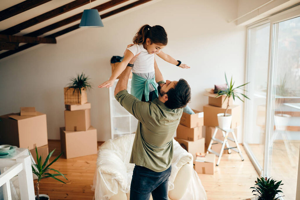 Счастливый отец-одиночка развлекается с дочерью во время переезда в новую квартиру.  - Фото, изображение