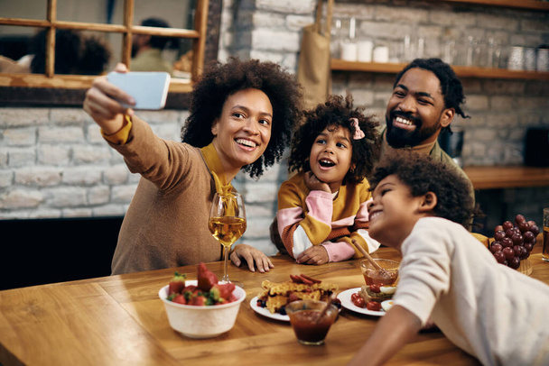 Happy black family having fun while taking selfie at home.  - Foto, afbeelding