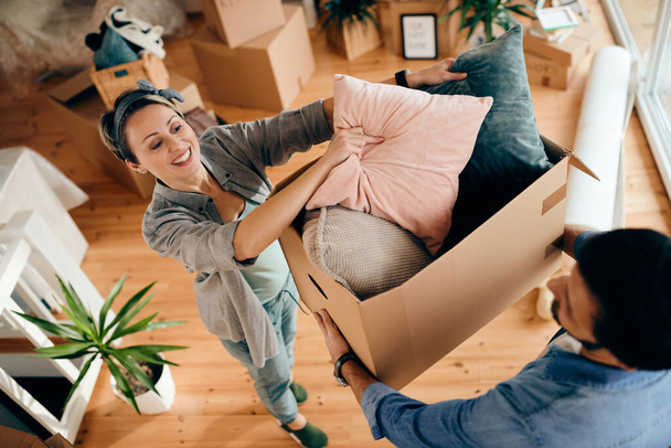 High angle view of happy couple unpacking their belongings at their apartment.  - Foto, Bild