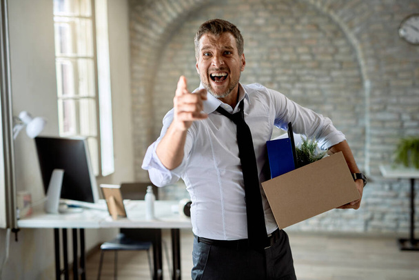 Angry businesswoman pointing at his index finger and screaming after getting fired from work.  - 写真・画像