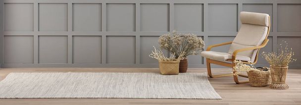 Jarrón de flores de algodón y decoración de la silla de mimbre en frente de la pared gris moderna, estilo alfombra. - Foto, Imagen
