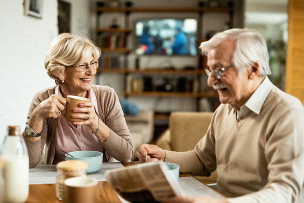 Gelukkig seniorenpaar genieten van het ontbijt thuis. Focus ligt op gelukkige oudere vrouw die koffie drinkt.  - Foto, afbeelding