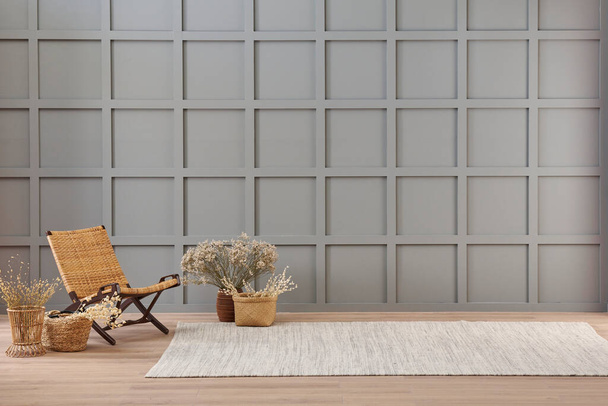 Vaas van katoen bloem en rieten stoel decoratie in de voorkant van de moderne grijze muur, tapijt stijl. - Foto, afbeelding
