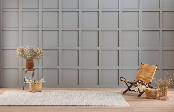 Vase of cotton flower and wicker chair decoration in front of the modern grey wall, carpet style. - Fotoğraf, Görsel