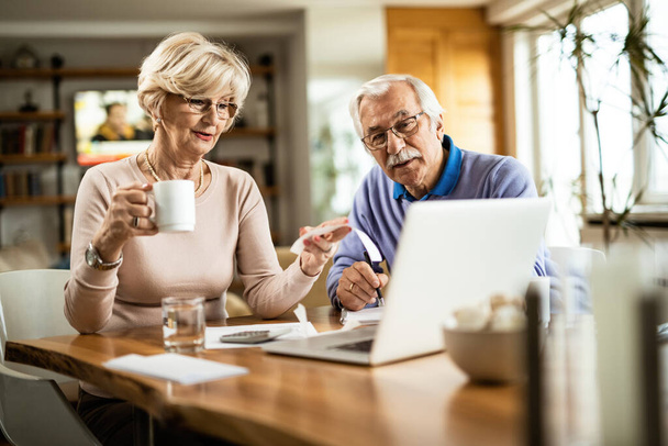 Mature couple analyzing their financial bill while paying them over computer at home.  - Photo, Image