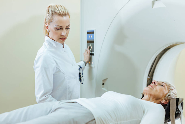 Žena radiolog a zralý pacient během MRI skenování v nemocnici.  - Fotografie, Obrázek