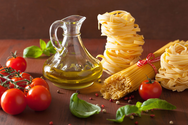 raw pasta olive oil tomatoes. italian cuisine in rustic kitchen - Photo, Image