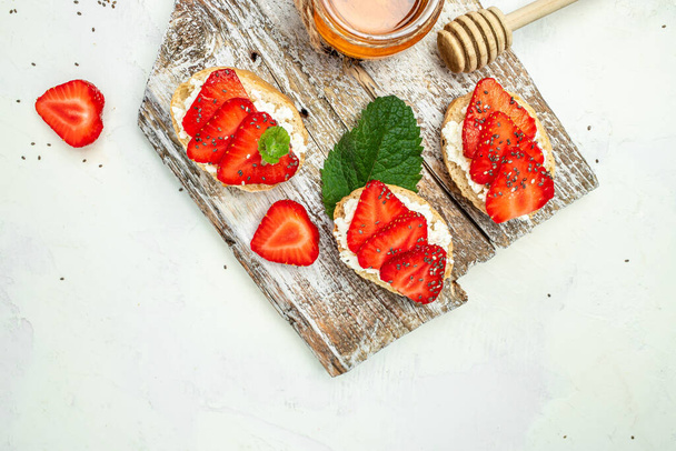 Bruschetta with strawberry and cream cheese ricotta on a light background. banner menu recipe place for text. - Photo, Image