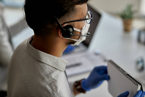 Close-up of customer service representative working at call center during virus pandemic.  - Foto, Bild