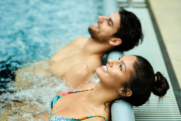 Happy couple leaning their heads at the edge of a pool while relaxing in thermal water at the spa.  - Zdjęcie, obraz