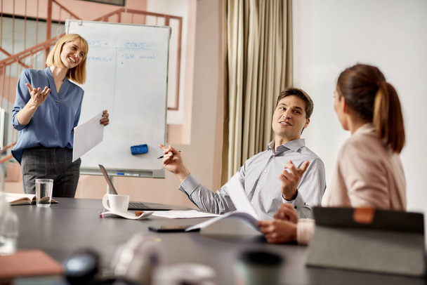 Группа предпринимателей общается во время деловой встречи в офисе. Сосредоточьтесь на бизнесмене.  - Фото, изображение
