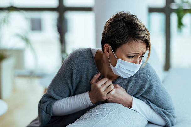 Young woman feeling sick and having chest pain while coughing at home.  - Foto, Bild
