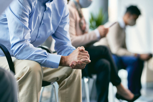 Unrecognizable male candidate with folded hands waiting for job interview. - 写真・画像