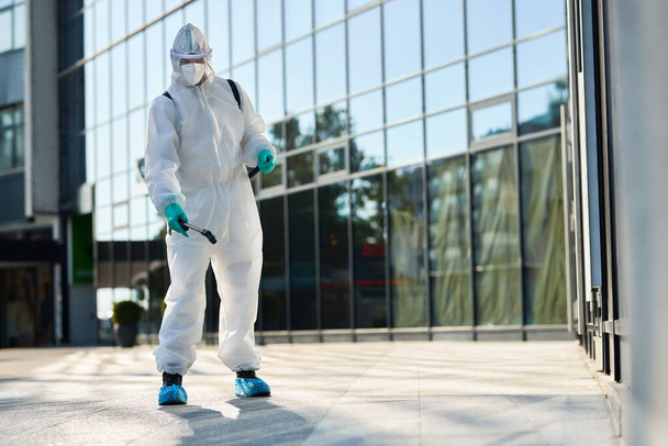 Disinfection worker spraying city streets in order to prevent the spread of COVID-19 epidemic.  - 写真・画像