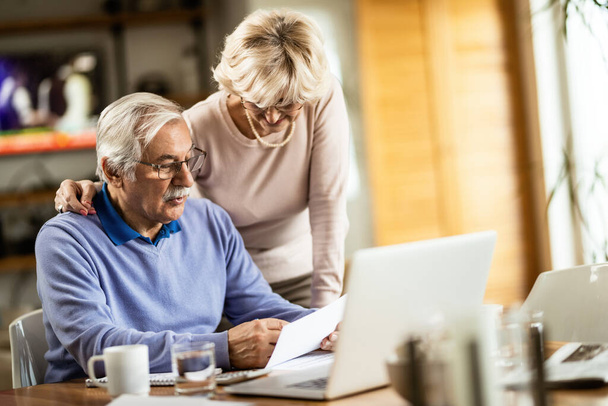 Senior couple making plans about their monthly finances and communicating at home. - Foto, Imagem