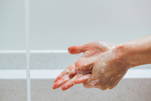 Lähikuva nainen puhdistaa kädet saippualla kylpyhuoneessa.  - Valokuva, kuva