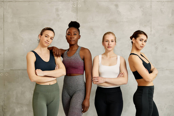 Portrait of confident multi-ethnic group of sportswomen against the wall. Copy space. - Photo, Image