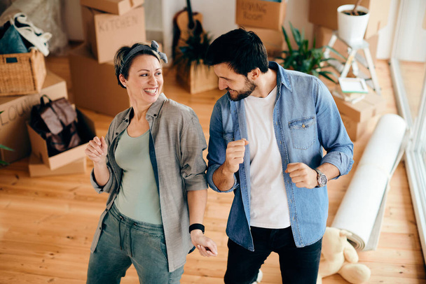 Happy couple having fun and dancing while moving into a new home. - Foto, immagini