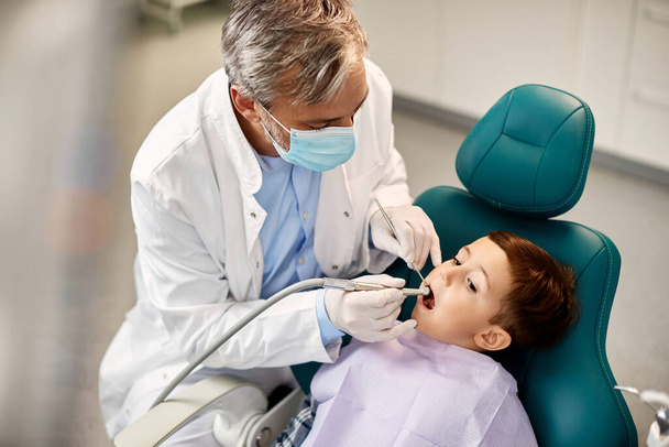 Маленький хлопчик проходить обстеження зубів під час прийому в стоматологічну клініку
. - Фото, зображення