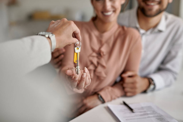 Close-up of a couple receiving keys of their new home from real estate agent.  - Φωτογραφία, εικόνα