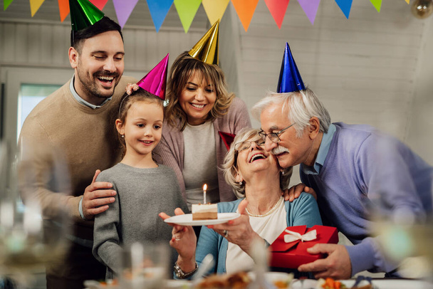 Щаслива розширена сім'я святкує День народження старшої жінки і дивує її тортом
.  - Фото, зображення