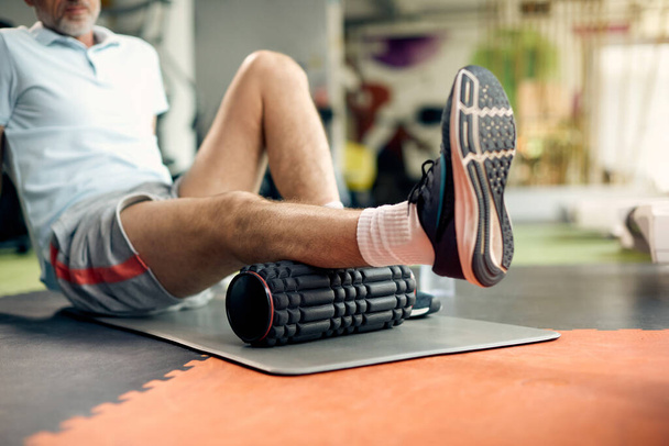 Close-up of athlete uses foam roller while warming up in gym. - Foto, Imagem