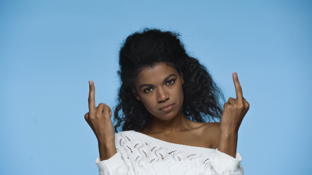 rude african american woman in white knitted sweater showing middle fingers isolated on blue - Фото, зображення