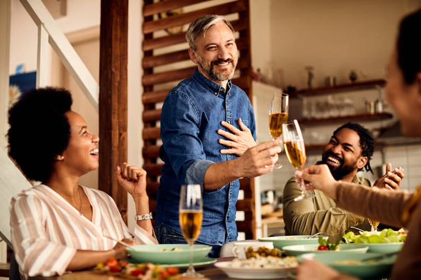 Happy md adult man feeling grateful and toasting with is friend during a meal at dining table.  - Foto, immagini
