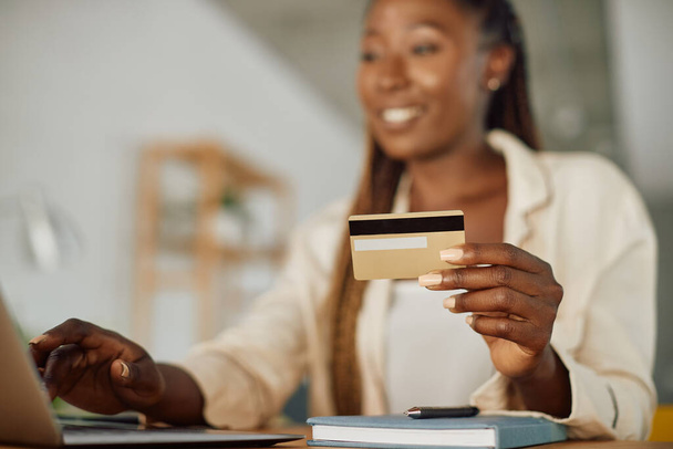 Close-up of African American woman using laptop and credit card for online shopping at home. - Foto, Bild