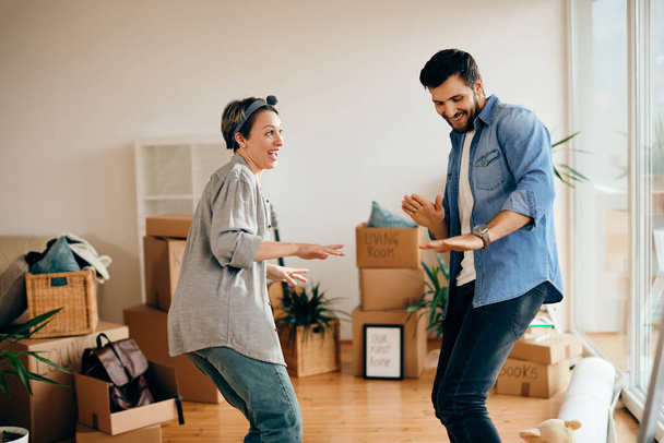 Carefree couple having fun and dancing after moving into new home. - Photo, Image