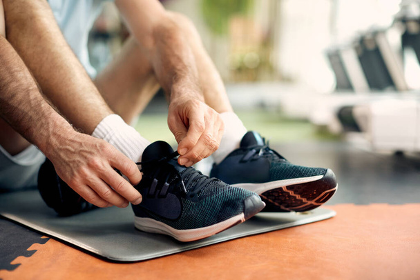 A sportoló férfi cipőfűzőt kötött a tornacipőre sport közben - Fotó, kép