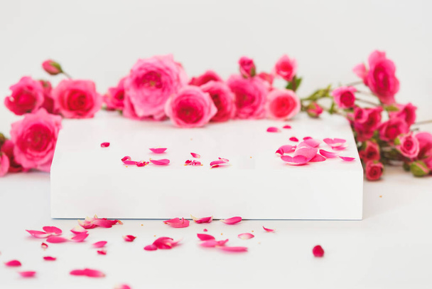 Empty podium with  rose flowers on white background. Abstract  background for product presentation , gift or cosmetics - Foto, imagen