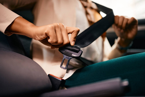 Close-up of woman fastening her seatbelt in a car. - Photo, image