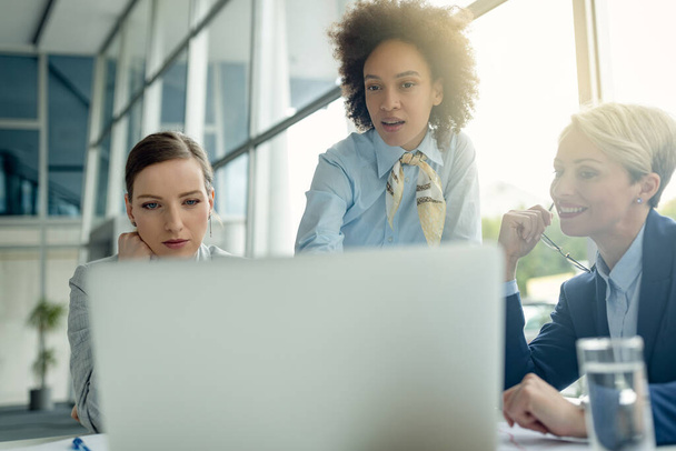 Kleine groep zakenvrouwen werkt samen terwijl ze laptop gebruiken op een vergadering in het kantoor. - Foto, afbeelding