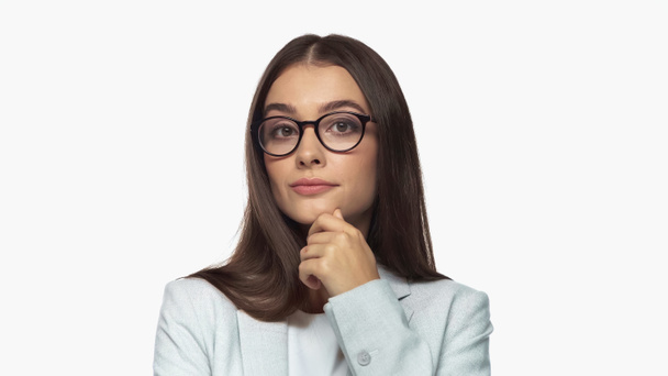 pretty young businesswoman in grey blazer and eyeglasses looking at camera isolated on white - Fotó, kép