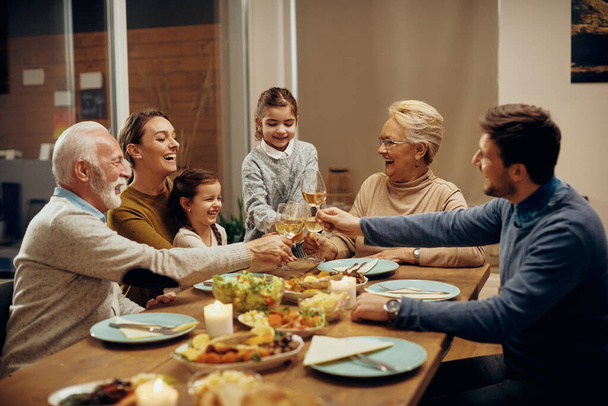 Happy multi-generation family having fun while toasting at dining table. - Foto, Bild