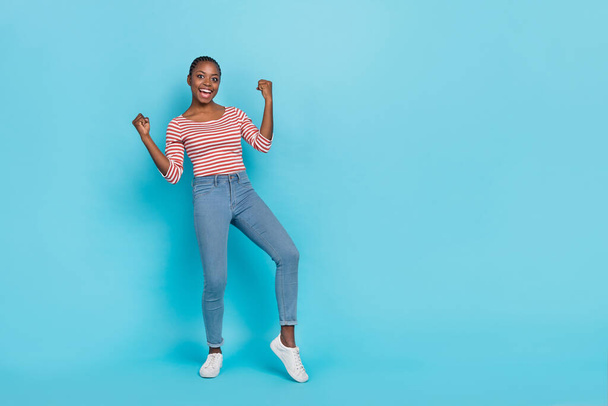 Full body portrait of excited overjoyed person raise fists triumph luck empty space isolated on blue color background. - Foto, Imagen
