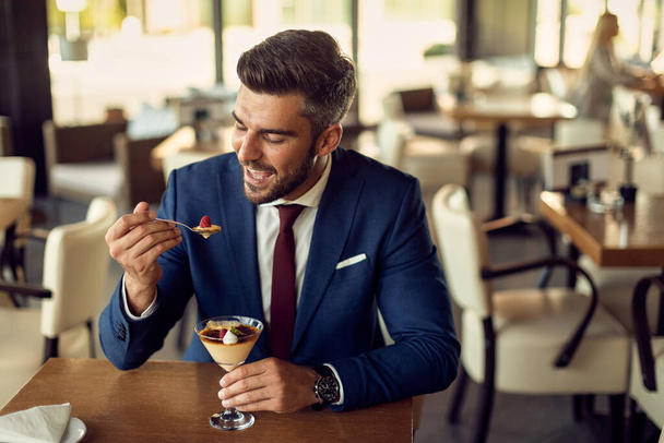 Male entrepreneur enjoying in a dessert while relaxing in a cafe.  - Φωτογραφία, εικόνα