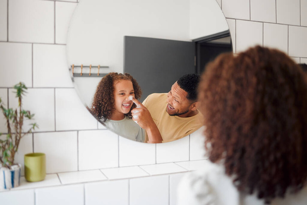 Happy mixed race father and daughter washing their hands together in a bathroom at home. Single African American parent teaching his daughter about hygiene while having fun and being playful. - Foto, imagen