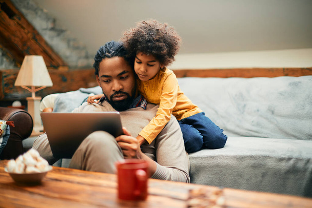 African American father and his daughter surfing the net on a computer at home. - Foto, Bild