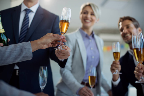 Close-up van ondernemers drinken Champagne terwijl het vieren van zakelijk succes op office party.  - Foto, afbeelding